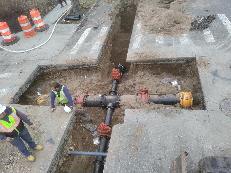 Underground utility networks visible in an open trench before as-built surveying